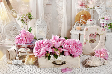 Pink peonies in old wooden drawer on the table in shabby chic style interior