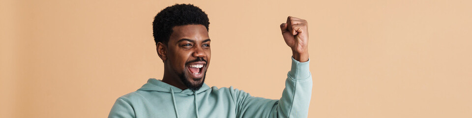 Obraz premium Black bearded young man smiling and using cellphone