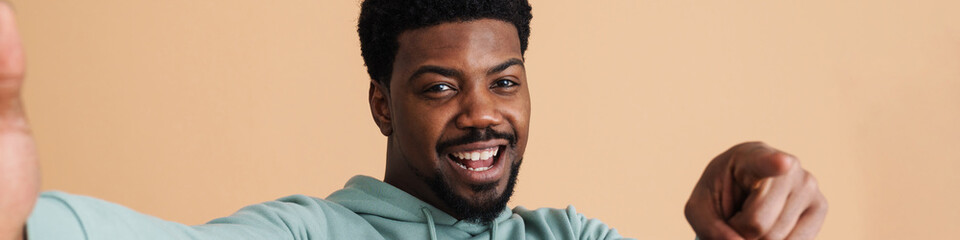 Obraz premium Black bearded young man smiling and taking selfie photo