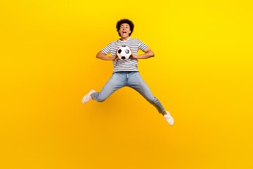 Fototapeta na wymiar Full body photo view of young handsome goalkeeper guy jump fun screaming catch playing football game isolated on yellow color background