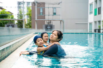 Child boy and girl swimming with mom in condominium swimming pool