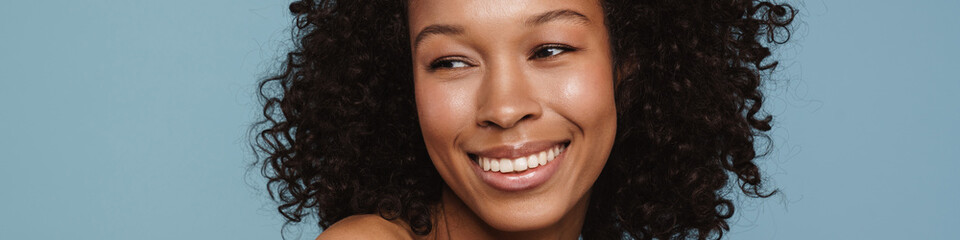 Shirtless black woman looking aside and laughing