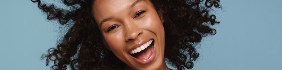 Shirtless black woman making fun with her hair and laughing