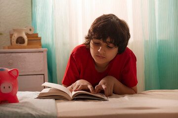 Portrait of a little boy reading a book