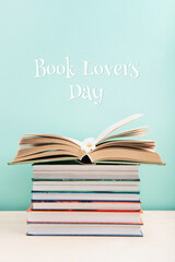 Open Book on Wooden Table and Stack of books on Blue Mint Background