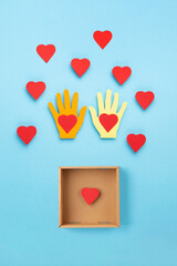 World Humanitarian Day Concept. Red Paper Hearts and Donation Box on Blue Background.