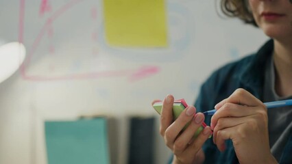 Glass, female analyst writes a note note using a glass wall in creative office. business data analyst conducts analytical knowledge in the field of business with the help of modern technologies, graph - Powered by Adobe
