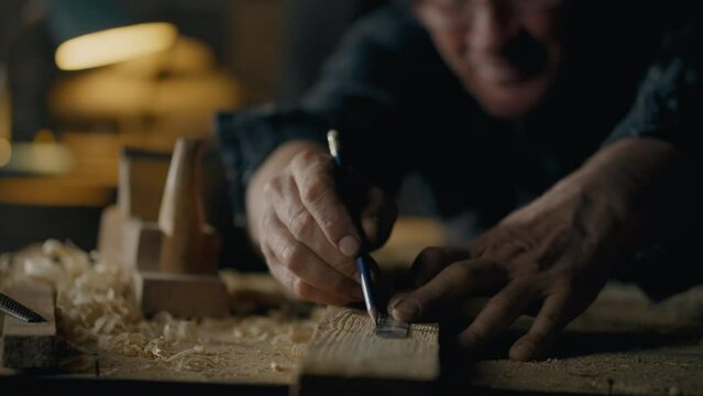 Handyman, Man Responsibly Marks marks with a pencil draws a line In a craftsman's workshop Close-up Active young craftsman Works with wooden blanks In a furniture workshop, workroom
