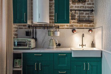 Modern retro-style kitchen with green cabinets and brick walls