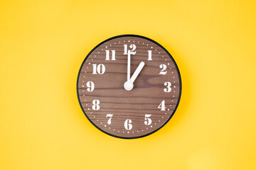 The Retro wooden clock at 1 O' clock on yellow color background.