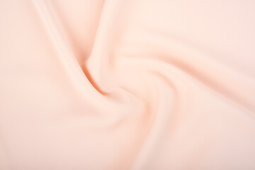 The texture of the satin fabric of beige color for the background