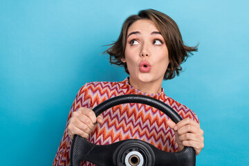 Photo portrait of lovely young lady hold steering wheel look empty space dressed stylish striped garment isolated on blue color background