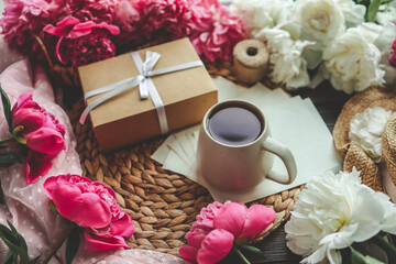 Beautiful spring composition, good morning concept. Cup of tea, peonies, gift box