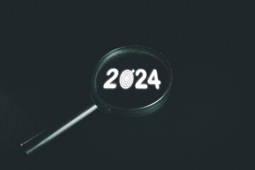 Magnifyglass focus on 2024 with dartboard icon on black background suitable for New Year 2024,Start up,Set up new plan,business,goal,target concept.