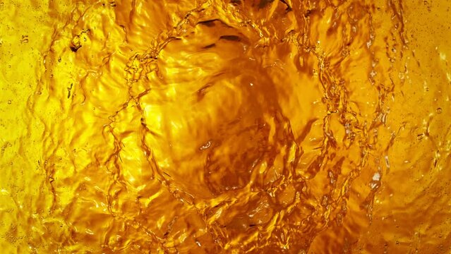 Super Slow Motion Shot of Waving Golden Alcohol Liquid Waves at 1000fps.