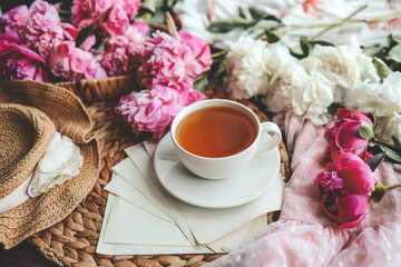 Beautiful spring composition, good morning concept. Cup of tea, peonies and open book