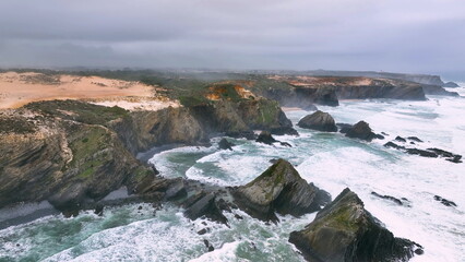 Obraz premium Aerial footage of the cliffs and beach in Portugal. Rota Vicentina. Slow motion ocean
