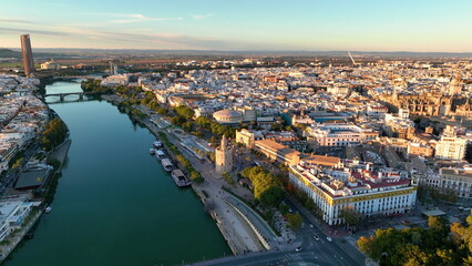 Fototapeta premium Aerial drone footage of the Seville city the Guadalquivir canal with the cathedral, the Torre del Oro, the tower of gold, Andalusia, Spaine