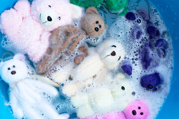 Soak toy teddy bears in laundry detergent water dissolution before washing.  Laundry concept, Top view