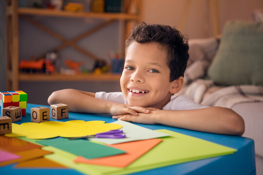 Photo of joyful little boy sit nursery table in domestic orphanage doing craft wait for best parents