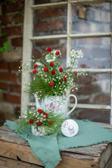 Natürlicher Blumenstrauß in alter Kaffeekanne, rustikale Tischdekoration, frische Blumen, roter Kugelamaranth, Schleierkraut