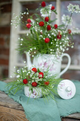 Natürlicher Blumenstrauß in alter Kaffeekanne, rustikale Tischdekoration, frische Blumen, roter Kugelamaranth, Schleierkraut