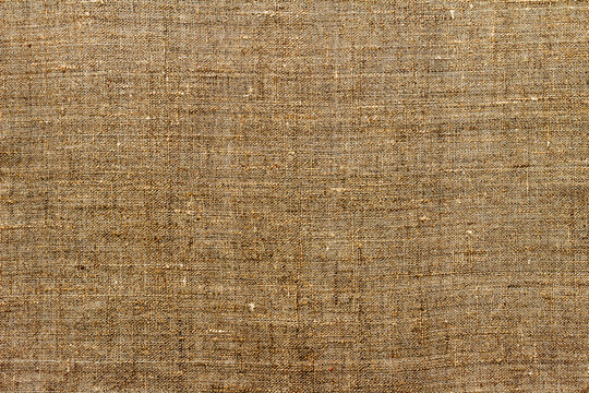 Natural linen fabric, background or texture, brown color, toned, top view, close up