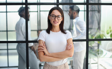 business woman with her staff in background at office