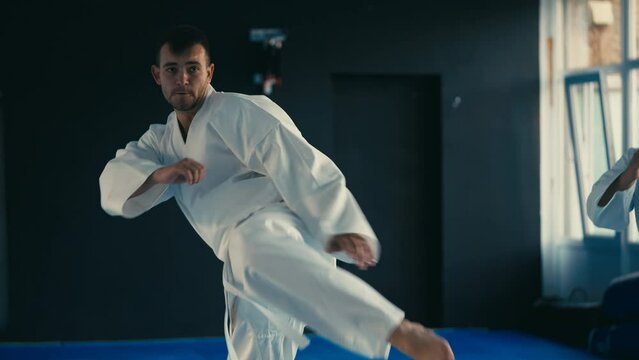 Taekwondo training, man in white uniform practicing punches and spinning kicks