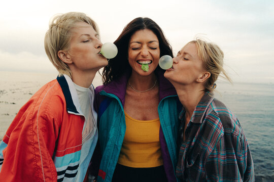 Three female friends blowing bubble bum and having fun
