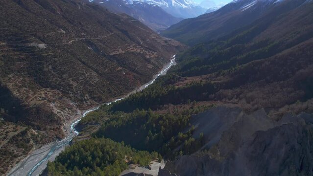 Aerial birds eye view Himalaya mountains range valley in sunny summer day with fresh river stream. Majestic breathtaking landscape Nepal river gorge and mountain peaks