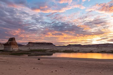 Photo sur Plexiglas Plage de Camps Bay, Le Cap, Afrique du Sud Panoramic view at sunset on solitary rock formations Lone Rock in Wahweap Bay in Lake Powell in Glen Canyon Recreation Area, Page, Utah, USA. Sand beach on wild campground. Red orange sky at sundown
