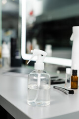 spray bottle with water, hairstyling equipment, salon services, hairstyling, hair trends, blurred background, beauty industry, hair care, professional salon tools, mirror and salon interior