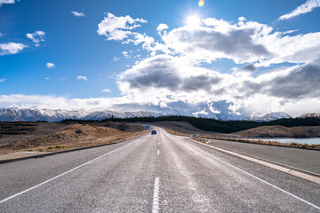 A scenic landscape of road to Aoraki Mount Cook - Lake Pukaki with blue sky and clouds, South Island, New Zealand. View from Tekapo- Twizel Road.
