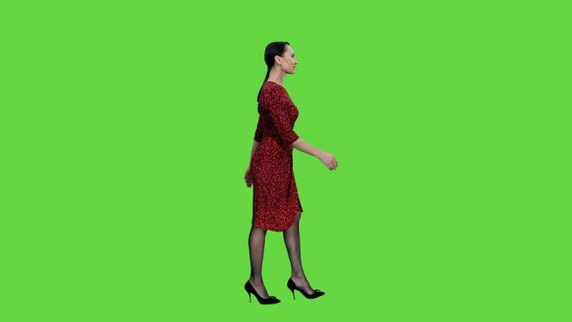 Side view of walking elegant adult woman in red dress and heels on green background, Chroma key, 4k pre-keyed footage