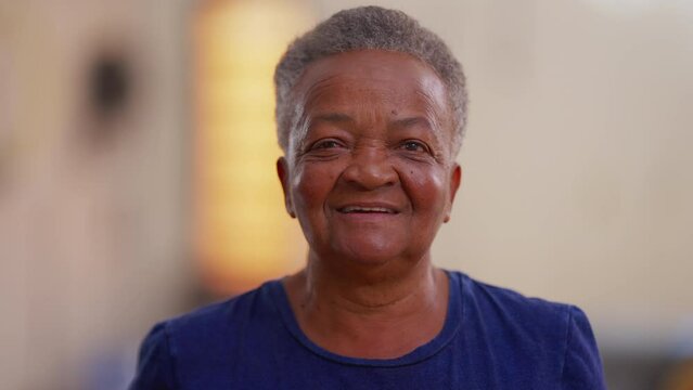 Happy African American elderly woman looking at camera smiling and laughing. Close-up face of an elderly black senior female person in 70s