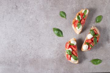 Tomato, basil and cheese fresh made caprese bruschetta. Italian tapas, antipasti with vegetables, herbs and oil on grilled ciabatta and baguette bread. Sandwich.