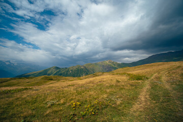 View of mountain tops, warm summer day, clouds in the sky, way to Ushba mountain and Koruldi lakes. Concept of vacation and travel to Georgia. Nature, Mestia, Svaneti mountains