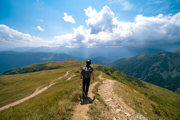 Man hiking to Koruldi lakes, beautiful view of Great Caucasus mountains close to Mestia in Upper...