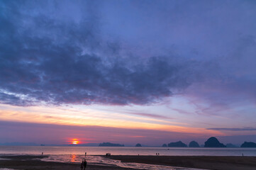 tourist watching sunset or sunrise  on beach with seascape and gold lighting sunset sky background