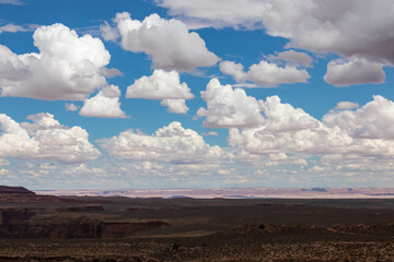 Panoramic aerial view of the Colorado Plateau in Grand Canyon National Park, Arizona, USA, America. Beautiful puffy clouds in the sky. Colorado River weaving through valleys and rugged terrain