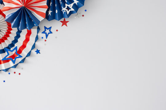 4th of July American Independence Day concept. Top view flat lay of patriotic folding fans, event confetti on white background with space for promo or message