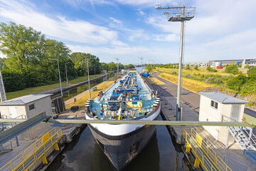 Picture of an inland transport ship in a lock on the river Main near Frankfurt - obrazy, fototapety, plakaty