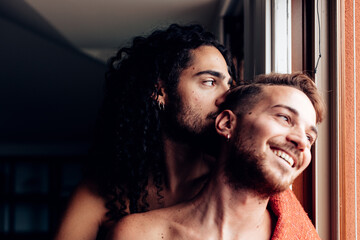 gay couple cuddling at home - Powered by Adobe