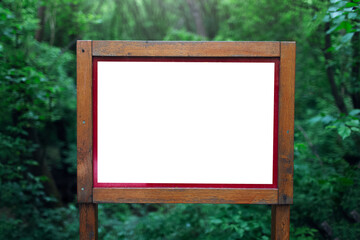 Close-up of wooden billboard with empty blank in forest. Mockup concept.