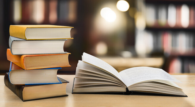 Book stack and open book on the desk in public library