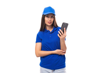 young woman promoter in a blue t-shirt and cap uses a smartphone