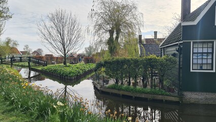Fototapeta premium Zaanse Schans, April 22, 2023: Netherlands rural lanscape Windmills at famous tourist site. park and fields landscape in Zaandam, north Holland, aerial view in sunrise light.