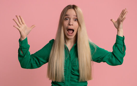 Excited amazed caucasian woman touching head and showing explosion, looking worried and shocked, celebrating success idea. Looking surprised of win wow girl isolated alone on pink studio background