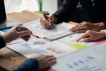 Group businessmen point to the material for the meeting, working together to plan to develop and solve common business problems. Concept of business management for growth and quality.